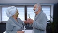 Senior couple man and woman in bathrobe are dancing in bathroom having fun enjoying leisure time Royalty Free Stock Photo