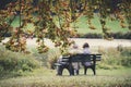 Senior couple man and woman are resting on a bench in the autumn park. Nymphenburg Palace Park in Munich