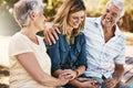 Senior couple in nature with their adult daughter sitting, talking and bonding together in a garden. Happy, love and Royalty Free Stock Photo