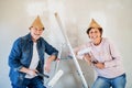 Senior couple painting walls in new home, having fun. Relocation concept. Royalty Free Stock Photo