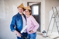 Senior couple painting walls in new home, laughing. Relocation concept. Royalty Free Stock Photo