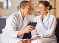 Senior couple, phone and relax spa wellness on sofa, beauty center and luxury body care or streaming video online Royalty Free Stock Photo