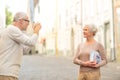 Senior couple photographing on city street