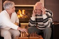 Senior couple playing chess at home