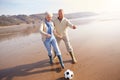 Senior Couple Playing Football On Winter Beach Royalty Free Stock Photo