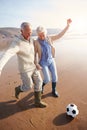 Senior Couple Playing Football On Winter Beach Royalty Free Stock Photo
