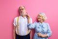 senior couple is playing isolated on pink background, have fun Royalty Free Stock Photo