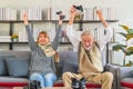 Senior couple playing video game together in living room Royalty Free Stock Photo