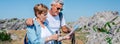 Senior couple with poles hiking looking map