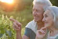 Senior couple posing in the park, man pointing with finger Royalty Free Stock Photo