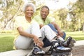 Senior Couple Putting On In Line Skates In Park Royalty Free Stock Photo