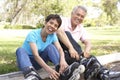 Senior Couple Putting On In Line Skates In Park Royalty Free Stock Photo