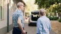 Senior couple putting luggage in car trunk Royalty Free Stock Photo