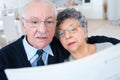 Senior couple reading newspaper together at home Royalty Free Stock Photo