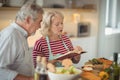 Senior couple reading recipe book while preparing meal Royalty Free Stock Photo