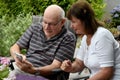 Senior couple reading text messages on mobile phone