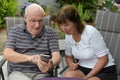 Senior couple reading text messages on mobile phone