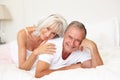 Senior Couple Relaxing On Bed