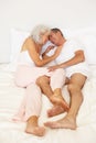 Senior Couple Relaxing On Bed Royalty Free Stock Photo