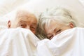 Senior Couple Relaxing In Bed Hiding Under Sheets Royalty Free Stock Photo