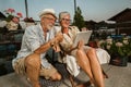 Senior couple relaxing outside and using tablet, making video call Royalty Free Stock Photo