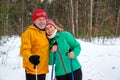 Elderly couple walking with nordic walking poles in snowy winter park Royalty Free Stock Photo