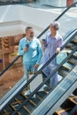 Senior couple riding down shopping mall escalator enjoying time together Royalty Free Stock Photo