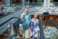 Senior couple riding down shopping mall escalator enjoying together Royalty Free Stock Photo