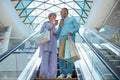 Senior couple riding down shopping mall escalator Royalty Free Stock Photo