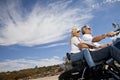 Senior couple riding motorcycle on desert road