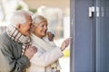 Senior couple ringing the doorbell to their guest house