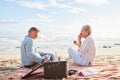 Senior couple, romantic beach picnic and smile together in summer for conversation, memory and comic time. Elderly man