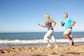Senior Couple Running Along Beach Royalty Free Stock Photo