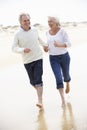 Senior Couple Running Along Beach Together Royalty Free Stock Photo