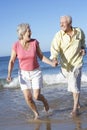 Senior Couple Running Along Beach Together Royalty Free Stock Photo