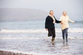 Senior Couple Running Along Winter Beach Royalty Free Stock Photo