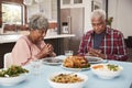 Senior Couple Saying Grace Before Meal Around Table At Home Royalty Free Stock Photo