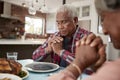 Senior Couple Saying Grace Before Meal Around Table At Home Royalty Free Stock Photo