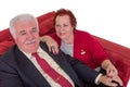 Senior couple seated on a red couch