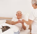 Senior couple, serving and coffee in bed, smile and relaxing together in retirement at home. Elderly people, bedroom and Royalty Free Stock Photo