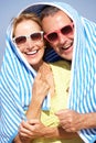 Senior Couple Sheltering From Sun On Beach Holiday