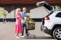 Senior couple with shopping cart at car trunk Royalty Free Stock Photo