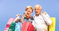 Senior couple shopping together with wife watching in husband bags - Elderly concept with mature man and woman having fun Royalty Free Stock Photo