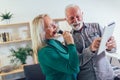 Senior couple singing karaoke at home