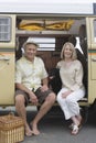 Senior Couple Sit In Campervan With Their Pet Dog