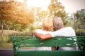 Senior couple siting on a bench and having romantic and relaxing time in a park