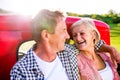 Senior couple sitting in back of red pickup truck Royalty Free Stock Photo