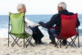 Senior Couple Sitting On Beach In Deckchairs Royalty Free Stock Photo