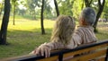 Senior couple sitting on bench, enjoying countryside weekend together, travel