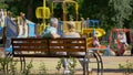 Senior couple sitting on bench near playground, watching grandchildren playing Royalty Free Stock Photo